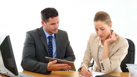 Business-colleagues-at-office-desk-using-tablet