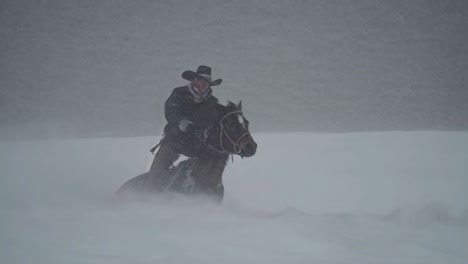 cowboy riding horse in a snowstorm