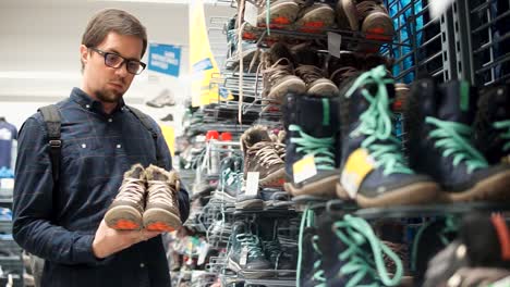 man shopping for hiking boots in a store