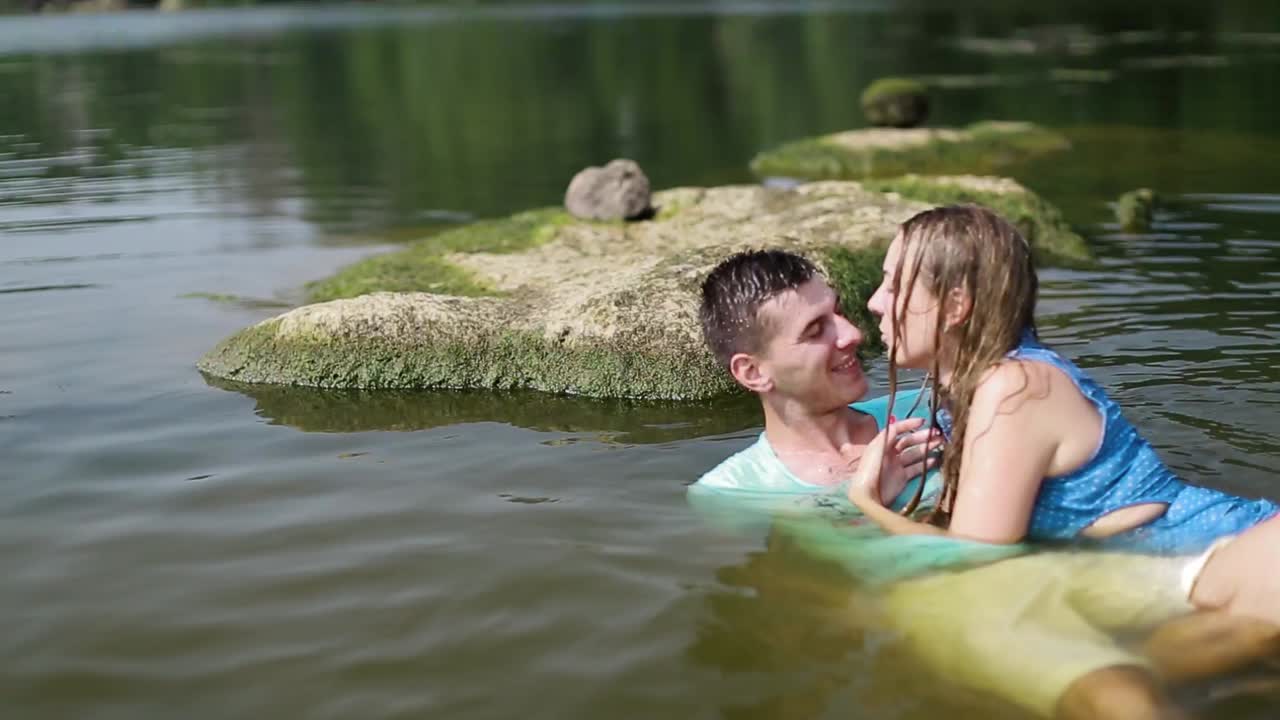 Romantic Couple Enjoying Outdoors. Handsome guy and beautiful girl resting in river