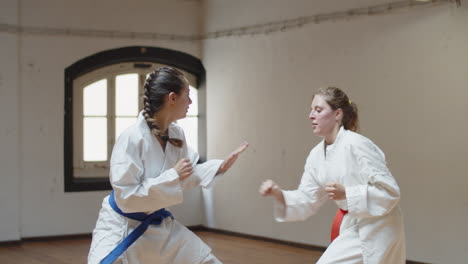 tracking shot of focused girls having karate class in gym