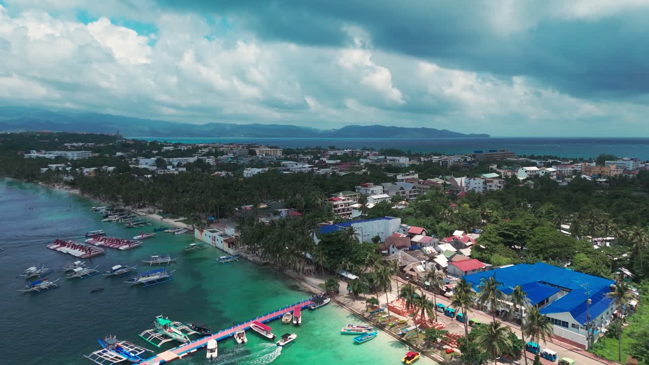 Dynamic 4K drone descent over Boracay’s coastline, palm-lined shore, colorful boats, and coastal town in the Philippines—perfect for travel, tourism, and tropical destination media