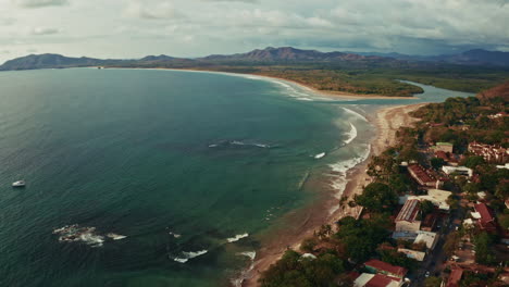aerial drone shot of tamarindo beach in costa rica. high view of the long stretching tropical breach and the turquoise ocean. summer holidays destination.
