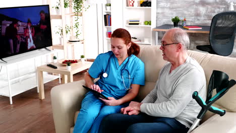 Female-caregiver-helping-old-man-in-nursing-home