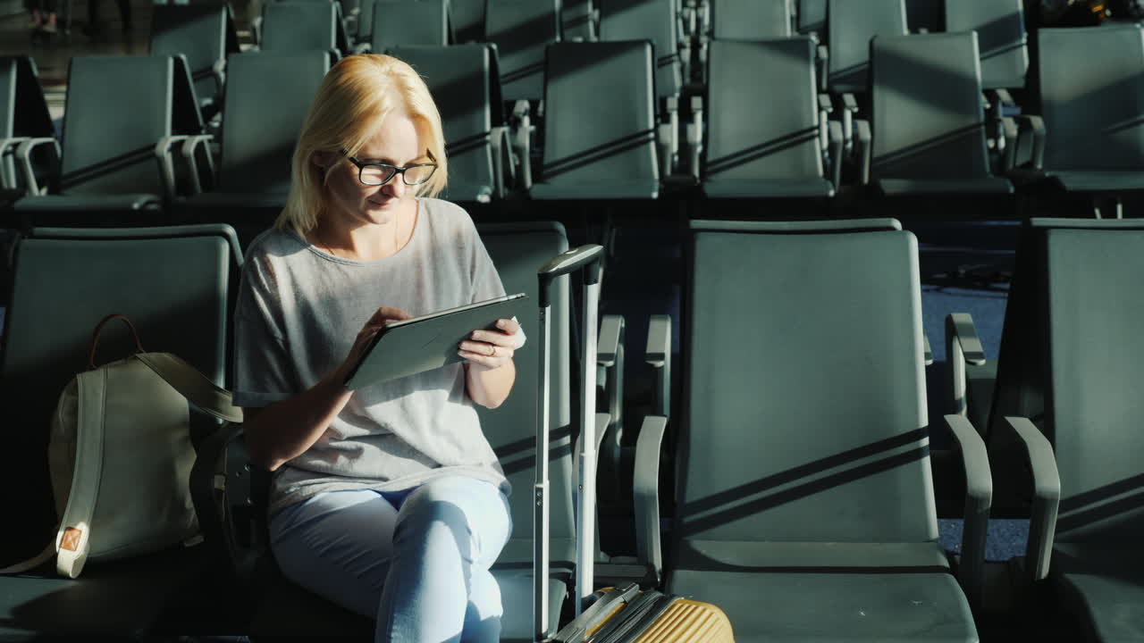 mujer usando tableta en la puerta del aeropuerto