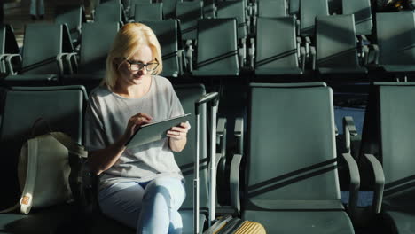 Frau-Mit-Tablet-Im-Flughafen-Gate