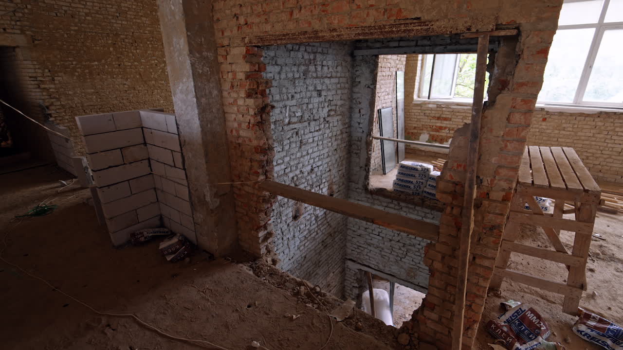 A pit in the building of old red bricks. Reconstruction process of an old-fashioned premise.