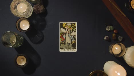 overhead shot of person giving tarot card reading laying down the tower, the high priestess and the wheel of fortune cards on table