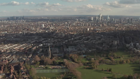 Dolly-back-reveal-shot-of-Clissold-park-with-London-skyscrapers-in-the-background