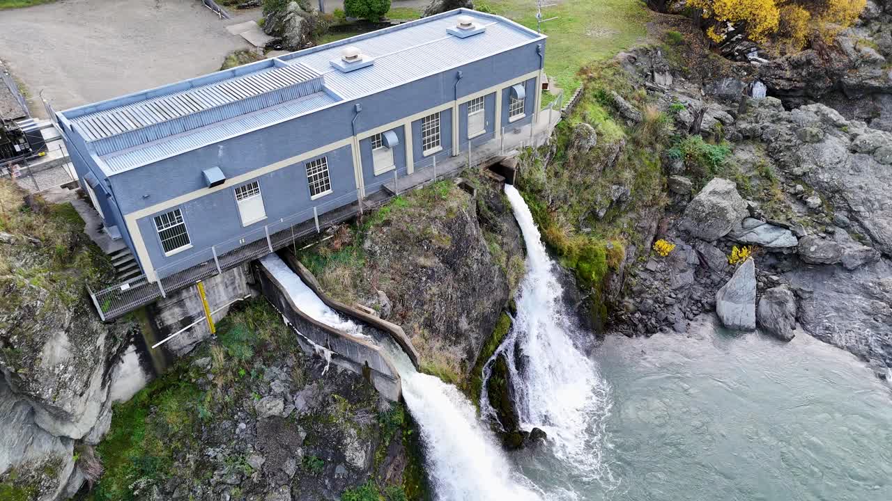 Drone footage captures a hydroelectric power station with water flowing into the Kawarau River in Queenstown, New Zealand