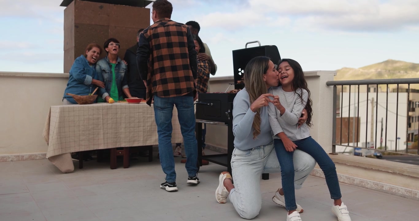 Woman and Little Girl Show Affection During Family Barbecue on Rooftop