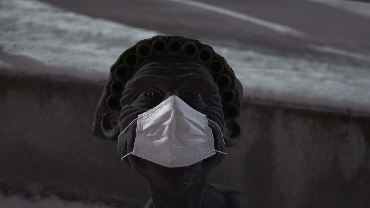 Statue Wearing a Face Mask in the Snow