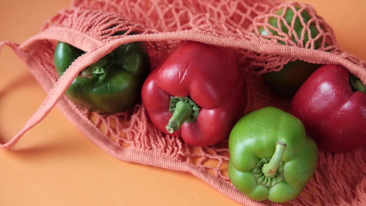 pimientos rojos y verdes en una bolsa de malla naranja