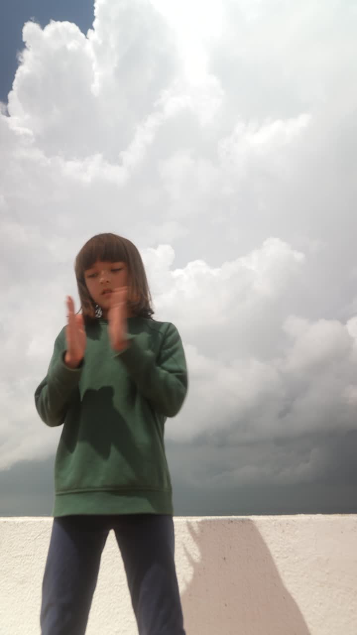 Girl playing outdoors under a cloudy sky