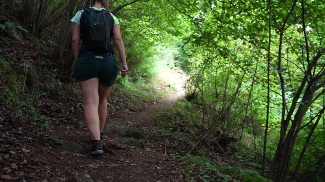 Mulher caminhando em uma floresta exuberante