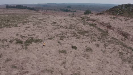 A-solo-female-hiker-treks-across-uneven-dry-grasslands