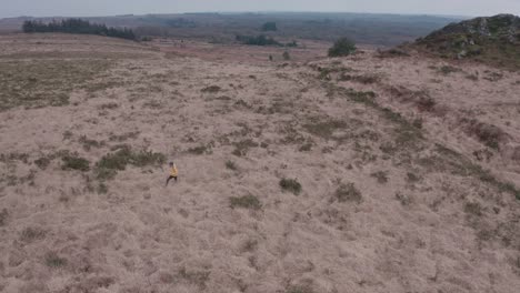 una excursionista femenina en solitario camina a través de praderas secas desiguales