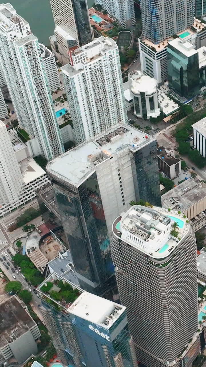 Miami, Flórida, EUA - 05 de janeiro de 2024: voo sobre arranha-céus e telhados de edifícios modernos no centro da cidade. Brickell City, centro de Miami. Vídeo vertical