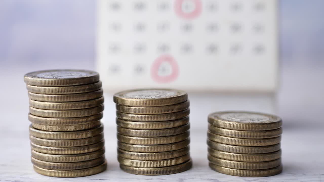 Pila di monete e calendario sul tavolo