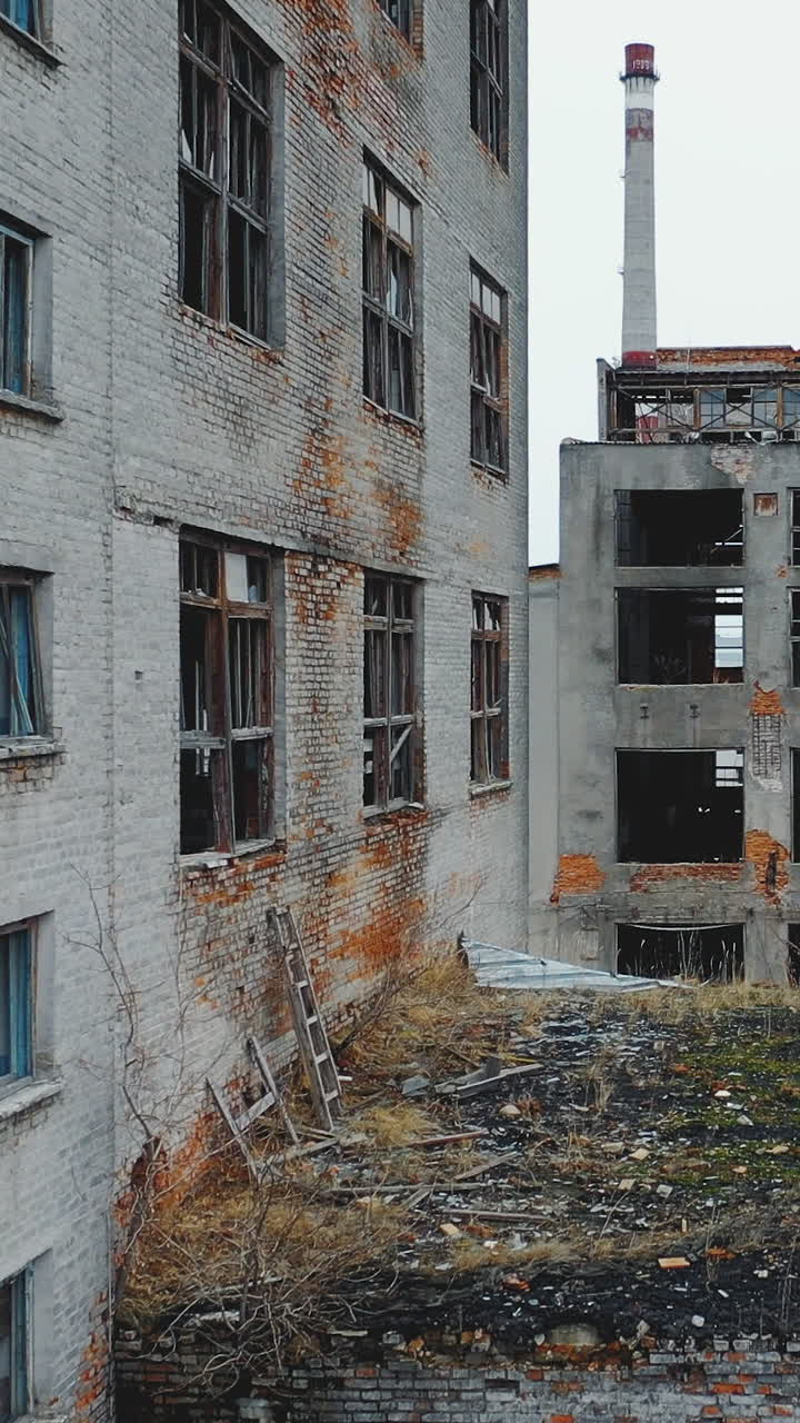 Aerial view of an old abandoned factory. Broken windows and doors. Vertical video