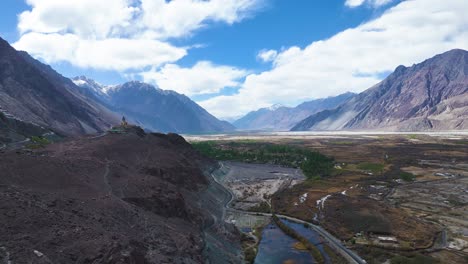 aerial drone shot capturing the historic diskit monastery with its colorful prayer flags fluttering against mountain backdrops.