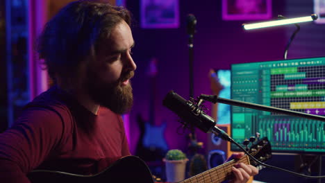 songwriter producing tunes on acoustic guitar in his personal studio