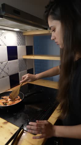 mujer cocinando camarones en la cocina