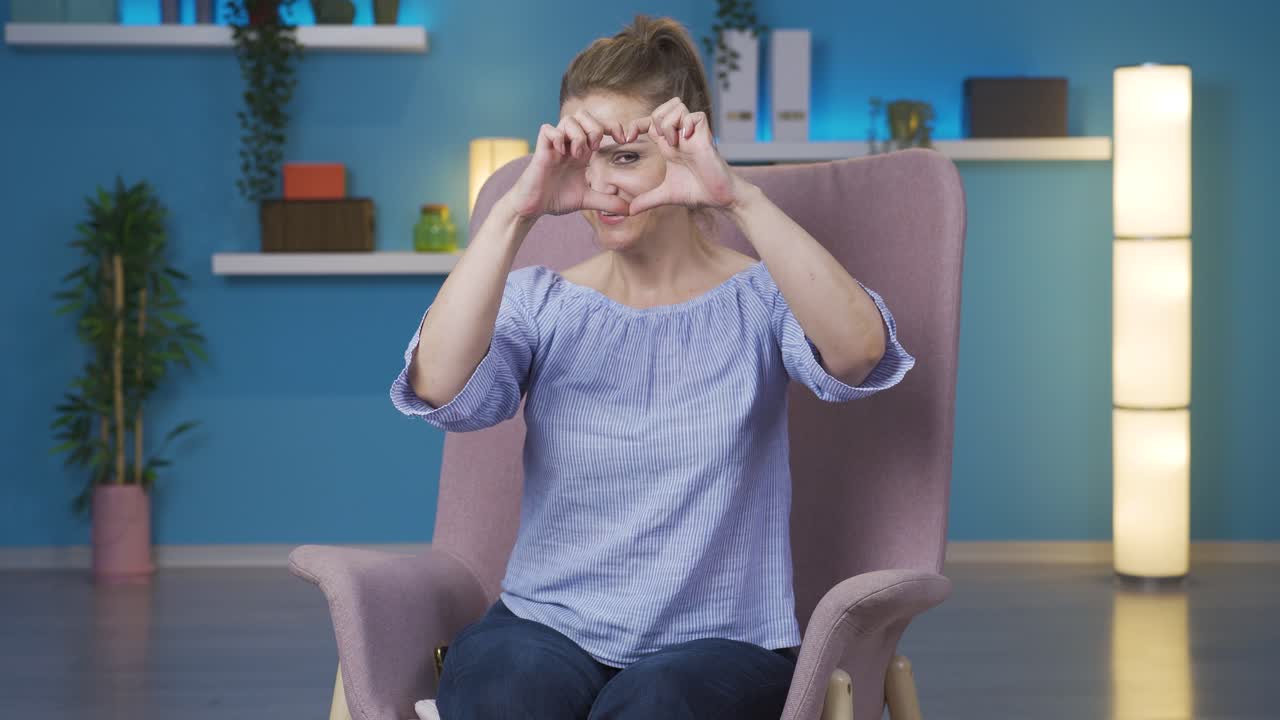 mujer haciendo el símbolo del corazón para la cámara.