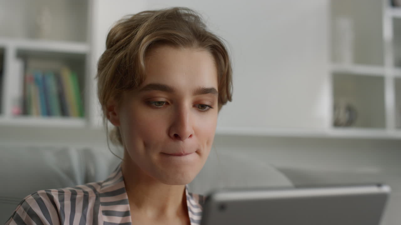 mujer seria navegando por internet morderse los labios en la sala de estar de cerca.