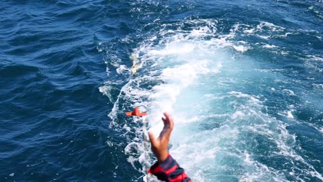 a person fishes in vibrant blue waters off phuket, thailand, capturing the dynamic motion of the sea and fishing line