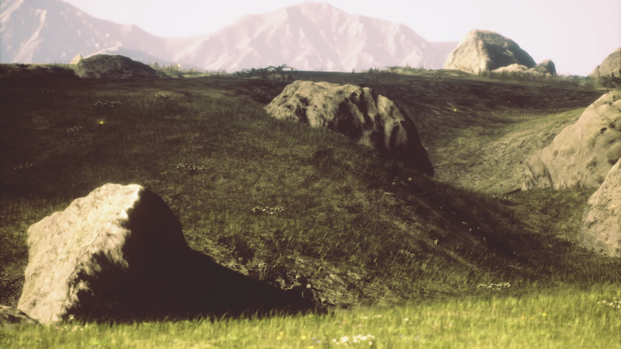 Landscape of grassy hills and rocky formations under bright sunlight