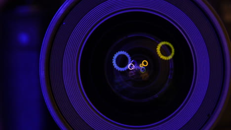 Colored-lights-moving-in-a-camera-lens-reflection,-photographic-objective-glass-under-low-light,-artsy-conceptual-video-concept