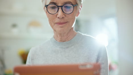 Senior-woman,-tablet-and-reading-in-home