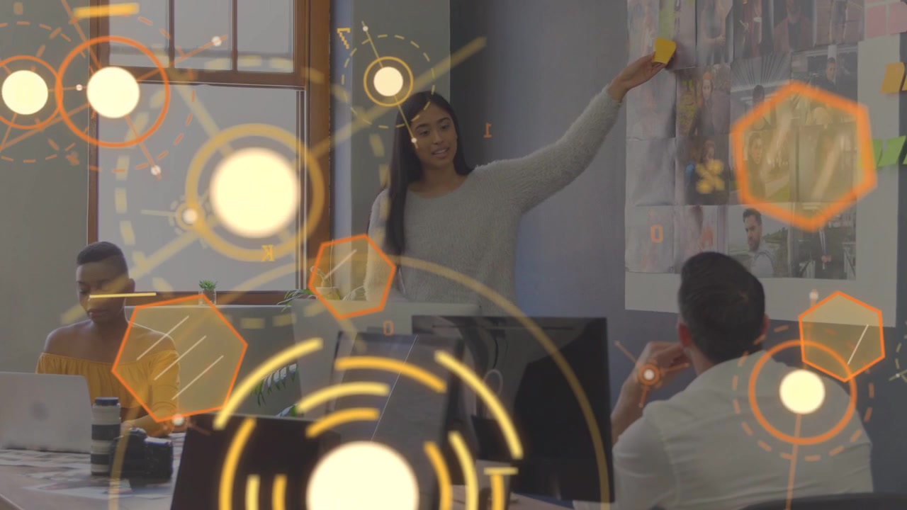 Responsabile che si alza dietro il monitor, posizionando post-it su stampe per la revisione del layout, con l'HUD che oscura parzialmente.
