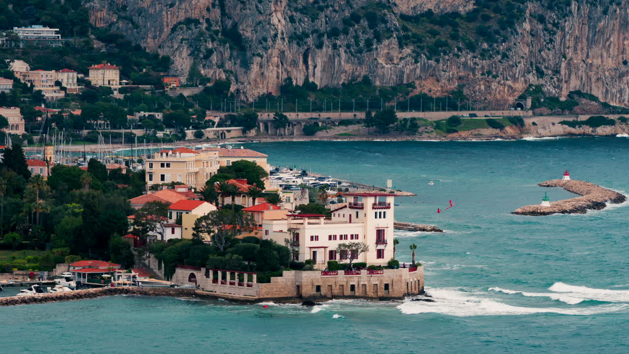 Beaulieu-sur-Mer, France - April 16, 2025: Distant view of the Villa Kerylos with the mountains on the background