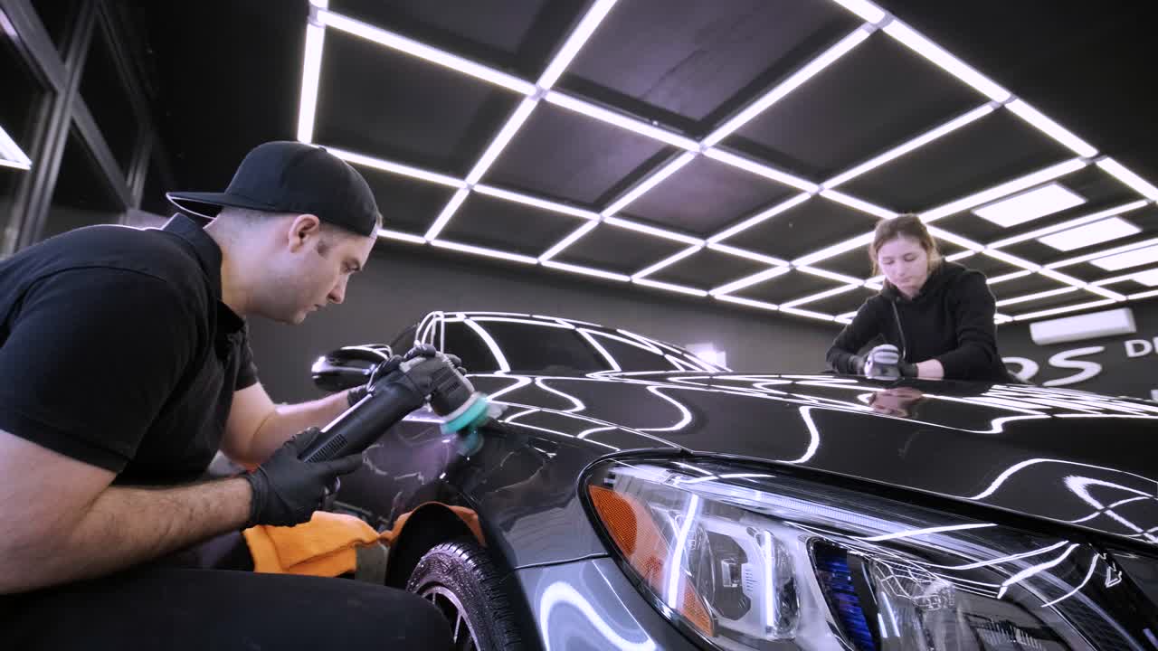 페인트 복원을 위해 기계와 폴리셔를 사용하는 전문 자동차 디테일링.