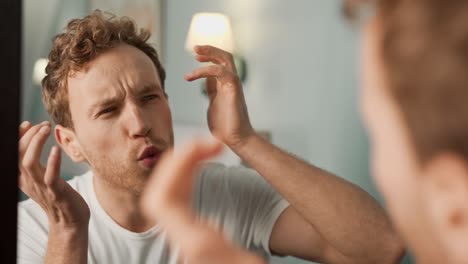 close-up portrait of a man in the mirror taking care of his problem skin