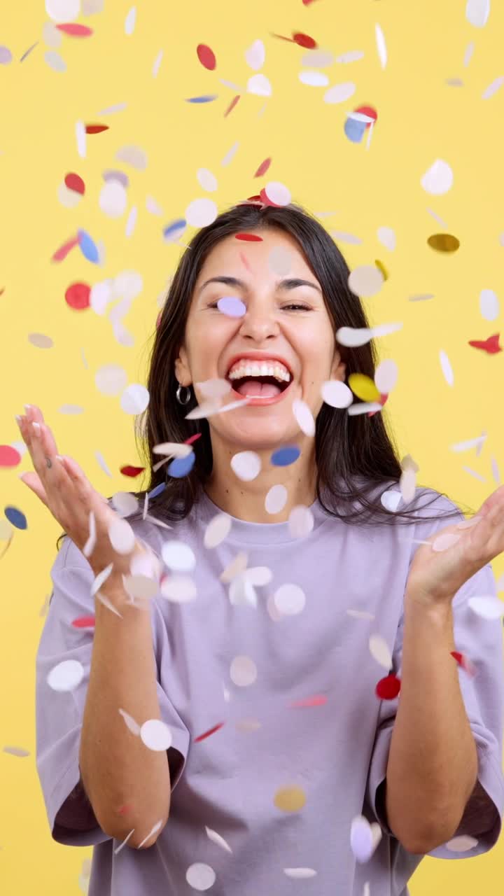 Mulher alegre rindo sob uma chuva de confetes