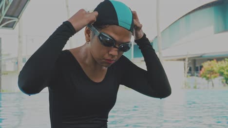 young asian woman swimmer adjusting her swim goggle before swimming