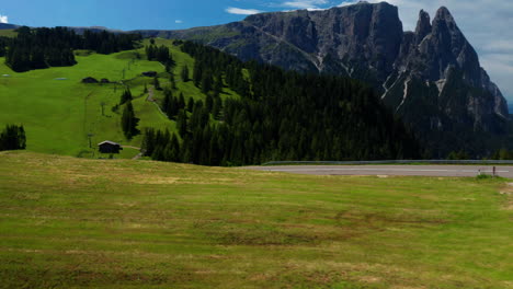 man bikes downhill through dolomites in italy, aerial shot