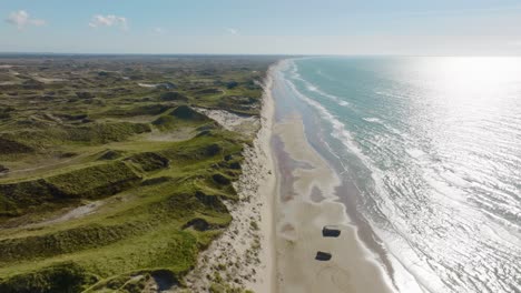 vista panorámica, dunas de arena, búnkeres de la segunda guerra mundial en una playa y vistas al mar del norte