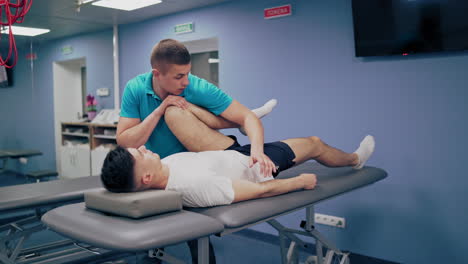 medical specialist embedding male's leg in the rehabilitation center. therapist worker doing massage on a patients' legs indoors.