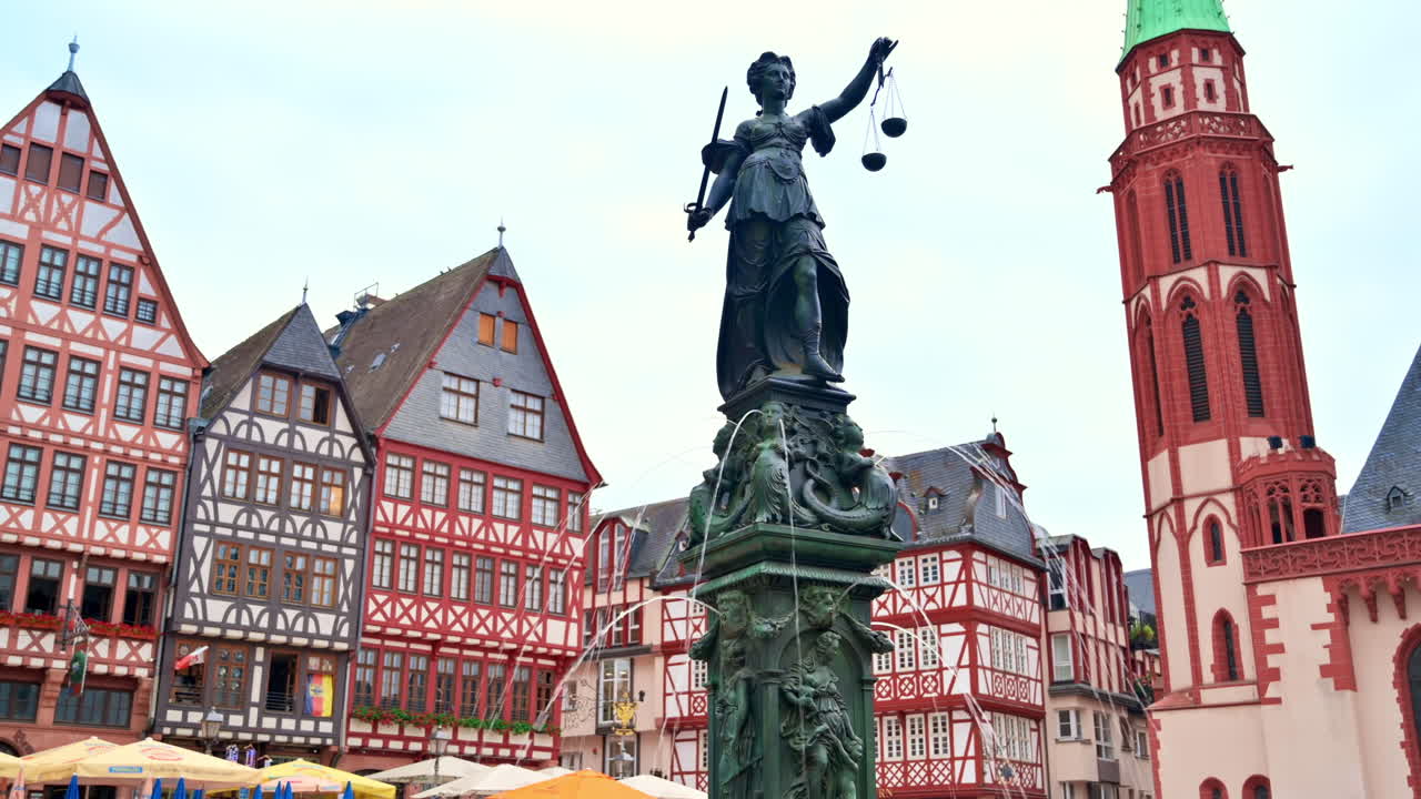 The Fountain Of Justice located in the Roemerberg, Frankfurt, Germany. Half-timbered buildings on the background