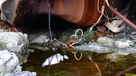 Schmutziges,-Stehendes-Wasserbecken-Und-Rostiges-Metall-Im-Freien-In-Der-Natur