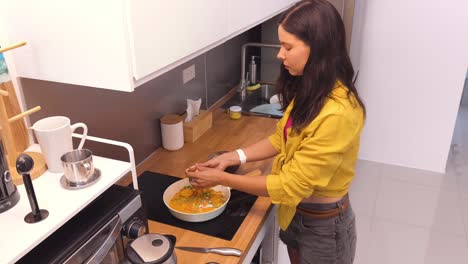 mujer cocinando desayuno en una cocina moderna