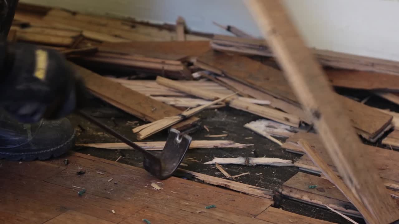 생산직 노동자가 물을 들어 올려 손상된 단단한 나무 바닥