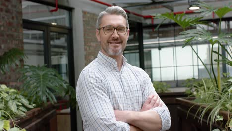 portrait of caucasian man with arms crossed smiling in the balcony at office