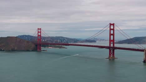 telephoto drone shot of the golden gate bridge with traffic and a boat underneath