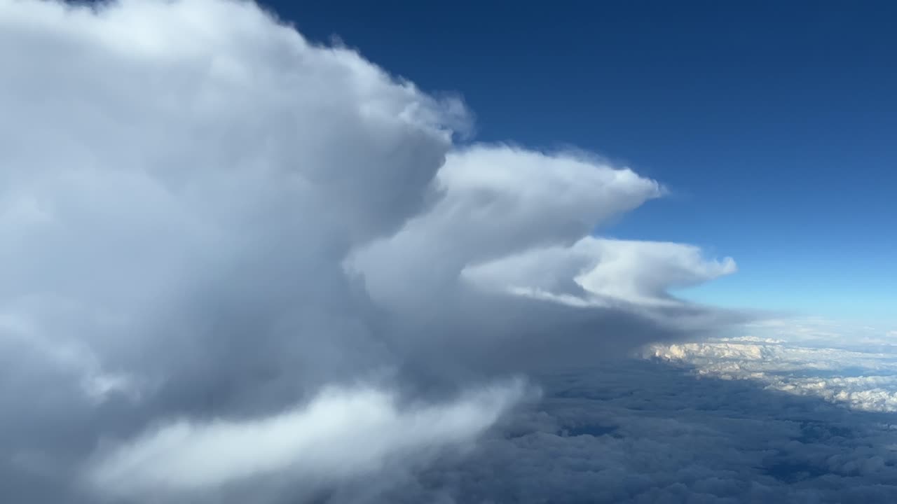 A pilot&rsquo;s perspective while flying next to some huge cumulonimbus, storm clouds on the left side