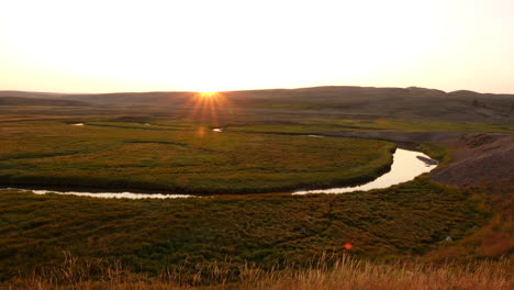 the sun sets in a clear sky over a tributary of the lamar river in yellowstone national park, wyoming